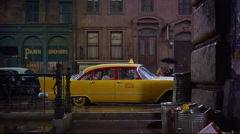 Movie still from “Breakfast at Tiffany's” (1961), directed by Blake Edwards – A yellow taxi cab parked on the side of the street; Extreme Wide shot, High angle