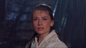 Movie still from “Breakfast at Tiffany's” (1961), directed by Blake Edwards – A person wearing a raincoat; Close Up shot, Low angle