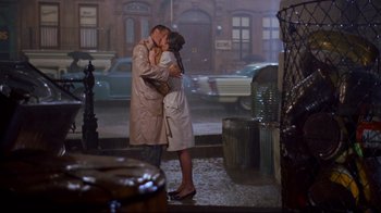 Movie still from “Breakfast at Tiffany's” (1961), directed by Blake Edwards – A man and a woman kissing on the sidewalk; Wide shot, High angle