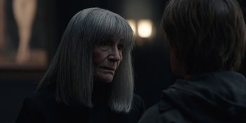 Movie still from “Dark” (2017), created by Baran bo Odar – An older woman with long gray hair looking at a younger man; Close Up shot, Over the shoulder angle