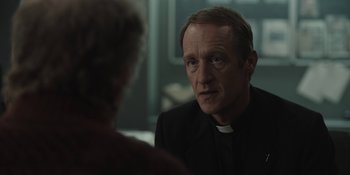 Movie still from “Dark” (2017), created by Baran bo Odar – A man wearing a priest's outfit talking to a woman; Close Up shot, Over the shoulder angle