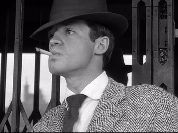 Movie still from “Breathless” (1960), directed by Jean-Luc Godard – A black and white photo of a man smoking a cigarette; Close Up shot, Low angle