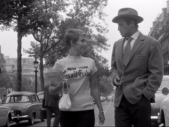 Movie still from “Breathless” (1960), directed by Jean-Luc Godard – A man and a woman walking down a street; Medium shot, Low angle