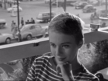 Movie still from “Breathless” (1960), directed by Jean-Luc Godard – Black and white photograph of a young woman in a striped shirt; Close Up shot, High angle