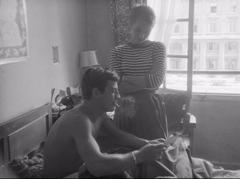 Movie still from “Breathless” (1960), directed by Jean-Luc Godard – A man and a woman in a room with a window; Medium shot, High angle