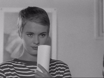 Movie still from “Breathless” (1960), directed by Jean-Luc Godard – A woman holding a cup in front of her face; Close Up shot, Over the shoulder angle