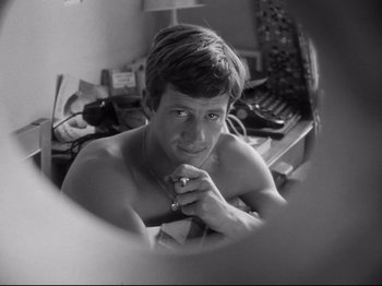 Movie still from “Breathless” (1960), directed by Jean-Luc Godard – A man sitting in front of a bathroom mirror; Close Up shot, High angle