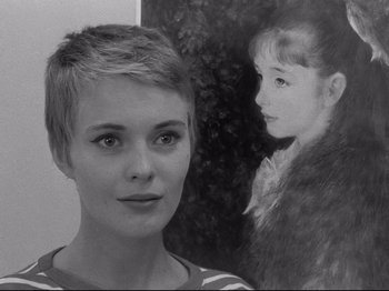 Movie still from “Breathless” (1960), directed by Jean-Luc Godard – A woman with short hair standing in front of a painting; Close Up shot, Over the shoulder angle