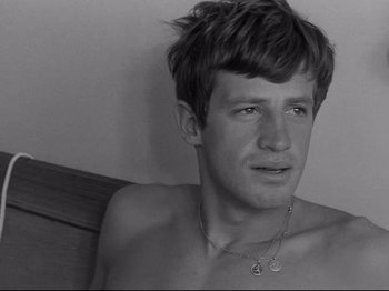 Movie still from “Breathless” (1960), directed by Jean-Luc Godard – A young man with his chest hanging out of his chest; Close Up shot, High angle