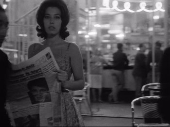 Movie still from “Breathless” (1960), directed by Jean-Luc Godard – A black and white photo of a woman reading a newspaper; Medium shot, Low angle