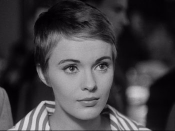 Movie still from “Breathless” (1960), directed by Jean-Luc Godard – A black and white photo of a woman with short hair; Close Up shot, Over the shoulder angle
