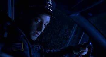 Movie still from “Bride of Chucky” (1998), directed by Ronny Yu – A police officer sitting in a car in the dark; Close Up shot, High angle