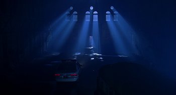 Movie still from “Bride of Chucky” (1998), directed by Ronny Yu – A car parked in front of a building with lights shining on it; Extreme Wide shot, Low angle