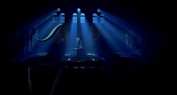 Movie still from “Bride of Chucky” (1998), directed by Ronny Yu – A person standing on a stage in a dark room; Extreme Wide shot, Low angle