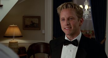 Movie still from “Bride of Chucky” (1998), directed by Ronny Yu – A man wearing a tuxedo and a bow tie; Close Up shot, High angle