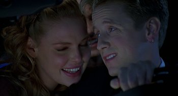 Movie still from “Bride of Chucky” (1998), directed by Ronny Yu – A woman and a man smiling at each other; Close Up shot, Over the shoulder angle