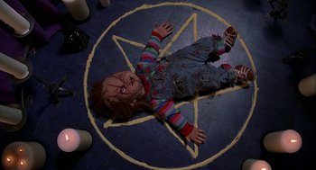 Movie still from “Bride of Chucky” (1998), directed by Ronny Yu – A chucky doll laying on the floor of a room; Wide shot, Overhead angle