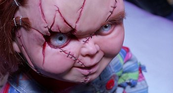 Movie still from “Bride of Chucky” (1998), directed by Ronny Yu – A creepy doll with stitches on its face; Extreme Close Up shot, Overhead angle
