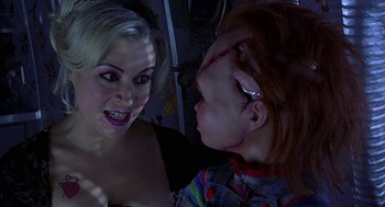Movie still from “Bride of Chucky” (1998), directed by Ronny Yu – A woman talking to another woman with makeup on her face; Close Up shot, Over the shoulder angle