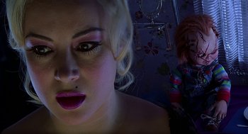 Movie still from “Bride of Chucky” (1998), directed by Ronny Yu – A woman with pink lipstick looking at the camera; Close Up shot, Overhead angle