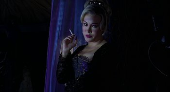 Movie still from “Bride of Chucky” (1998), directed by Ronny Yu – A woman holding a cigarette in her hand; Medium shot, Low angle