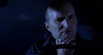 Movie still from “Bride of Chucky” (1998), directed by Ronny Yu – A man with his hand to his face looking to his left; Close Up shot, High angle