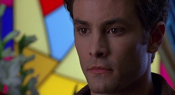 Movie still from “Bride of Chucky” (1998), directed by Ronny Yu – A man's face in front of a stained glass window; Close Up shot, Low angle