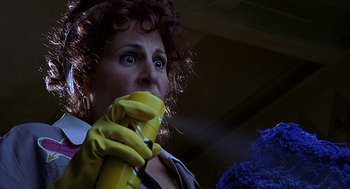 Movie still from “Bride of Chucky” (1998), directed by Ronny Yu – A woman holding a spray bottle and wearing yellow gloves; Close Up shot, Low angle