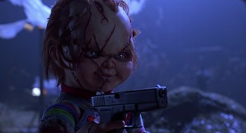 Movie still from “Bride of Chucky” (1998), directed by Ronny Yu – A child's play chucky doll holding a gun; Close Up shot, Low angle