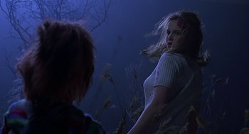 Movie still from “Bride of Chucky” (1998), directed by Ronny Yu – A woman standing next to a child in a field; Medium shot, Over the shoulder angle