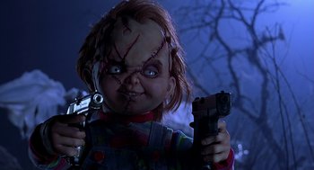 Movie still from “Bride of Chucky” (1998), directed by Ronny Yu – A chucky doll holding a toy gun in a dark room; Close Up shot, Low angle