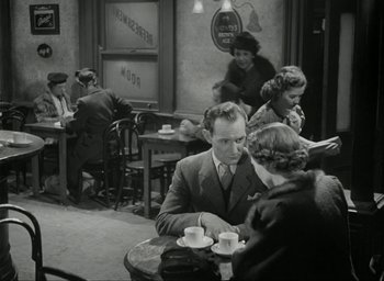 Movie still from “Brief Encounter” (1945), directed by David Lean – An old photo of people sitting at a table drinking coffee; Medium shot, High angle