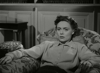 Movie still from “Brief Encounter” (1945), directed by David Lean – An old photo of a woman sitting in a chair; Medium shot, High angle
