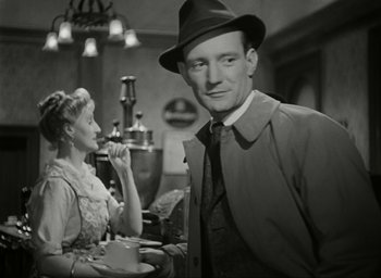 Movie still from “Brief Encounter” (1945), directed by David Lean – A man in a hat standing next to a woman in a dress; Medium shot, Over the shoulder angle