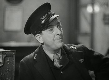Movie still from “Brief Encounter” (1945), directed by David Lean – A man wearing a uniform and a hat; Close Up shot, Low angle