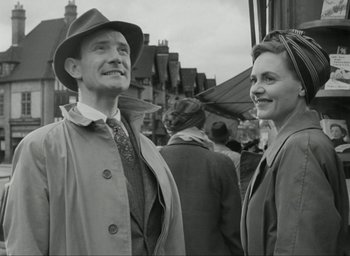 Movie still from “Brief Encounter” (1945), directed by David Lean – An older man and a younger woman standing next to each other; Medium shot, Low angle