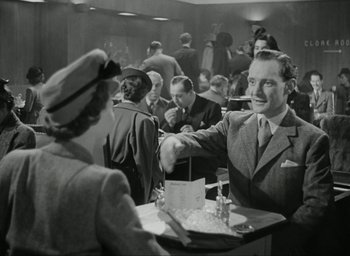 Movie still from “Brief Encounter” (1945), directed by David Lean – An old photo of people sitting at a table; Medium shot, Low angle
