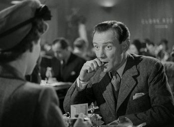 Movie still from “Brief Encounter” (1945), directed by David Lean – An old photo of a man sitting at a table eating; Close Up shot, Over the shoulder angle