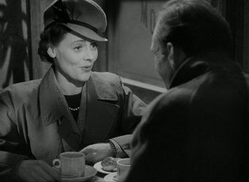 Movie still from “Brief Encounter” (1945), directed by David Lean – An old photo of two people sitting at a table; Medium shot, Over the shoulder angle