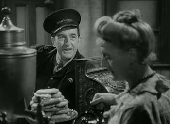 Movie still from “Brief Encounter” (1945), directed by David Lean – An old photo of a man and a woman sitting at a table; Medium shot, Over the shoulder angle