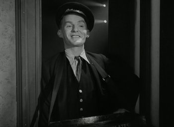 Movie still from “Brief Encounter” (1945), directed by David Lean – A man wearing a hat and a suit; Medium shot, Low angle