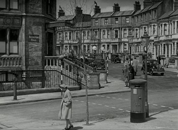 Movie still from “Brief Encounter” (1945), directed by David Lean – An old black and white photo of a woman walking down the street; Extreme Wide shot, High angle