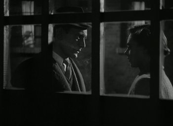 Movie still from “Brief Encounter” (1945), directed by David Lean – A black and white photo of a man and a woman looking at each other through a window; Close Up shot, Over the shoulder angle