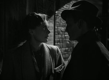Movie still from “Brief Encounter” (1945), directed by David Lean – A man and a woman standing next to each other in front of a brick wall; Close Up shot, Over the shoulder angle