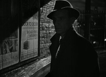Movie still from “Brief Encounter” (1945), directed by David Lean – A black and white photo of a man wearing a hat; Close Up shot, Over the shoulder angle