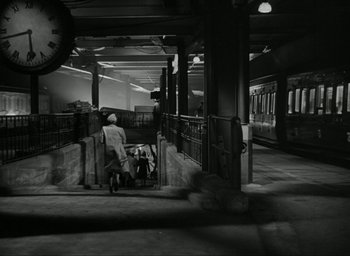 Movie still from “Brief Encounter” (1945), directed by David Lean – A man walking down a train platform with a bag; Extreme Wide shot, High angle