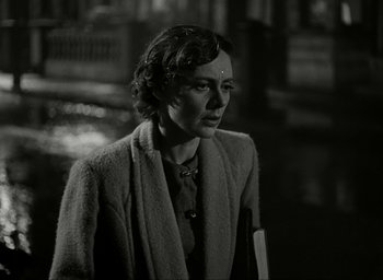 Movie still from “Brief Encounter” (1945), directed by David Lean – An old photo of a woman looking at the camera; Close Up shot, Over the shoulder angle