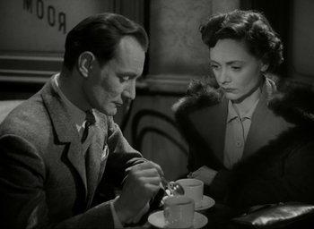 Movie still from “Brief Encounter” (1945), directed by David Lean – A man and a woman sitting at a table; Medium shot, High angle