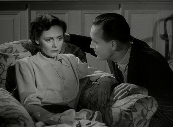 Movie still from “Brief Encounter” (1945), directed by David Lean – An older woman sitting on a bed next to an older man; Medium shot, High angle