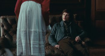 Movie still from “Bright Star” (2009), directed by Jane Campion – A man sitting on a couch in front of a woman; Medium shot, Over the shoulder angle